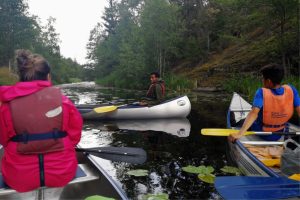 Bild från några unga vuxna under en kanottur arrangerat av Miljöverkstan Flaten, Äventyrsgruppen som anordnar gratis aktiviteter med fokus på friluftsliv för asylsökande och nya personer i Sverige.