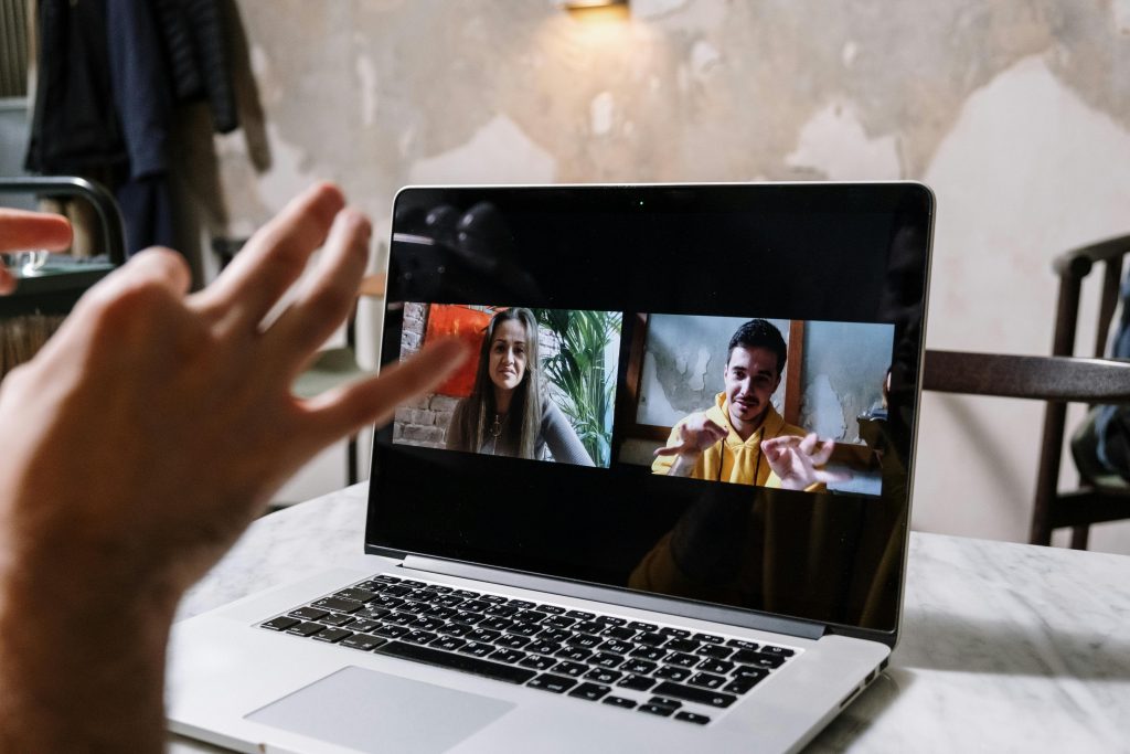 Närbild på skärm under ett digitalt möte där två personer, en man och en kvinna, syns i skärmen från mötet och gestikulerande pratar